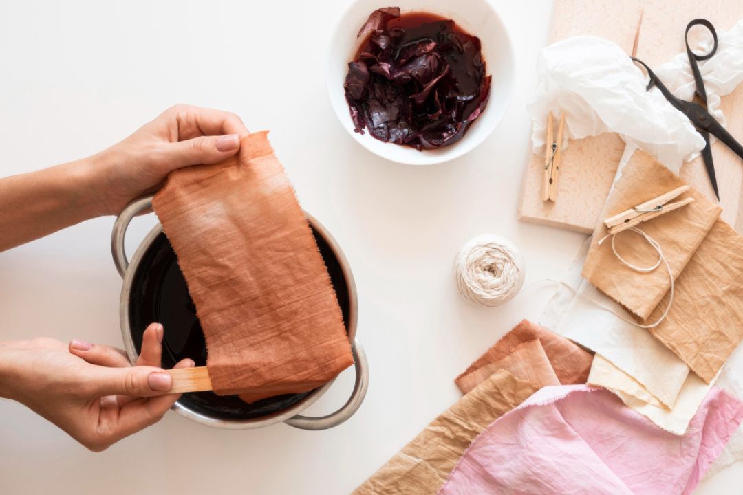 “Craftsman preparing sustainable garment with natural dyes”